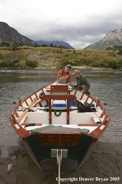 Flyfishermen choosing fly at driftboat.