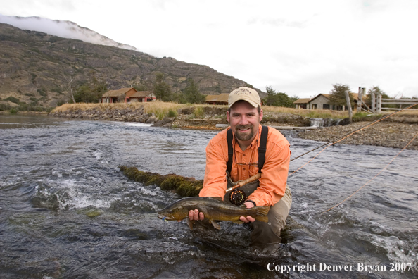 Flyfisherman holding brown trout.