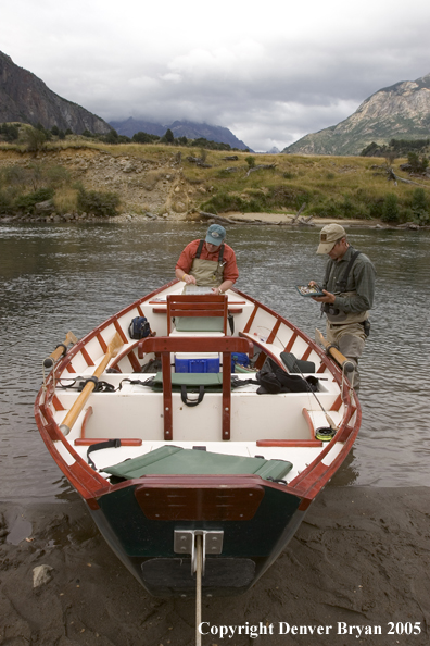 Flyfishermen choosing flies at driftboat.