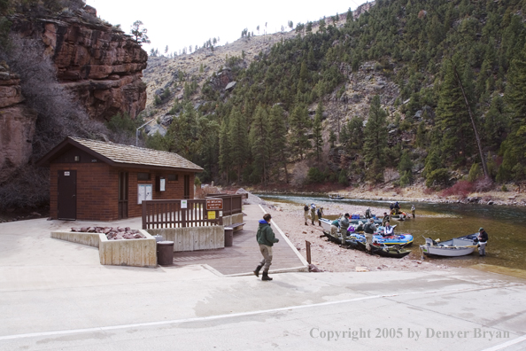 Fisherman and boats at boat ramp.