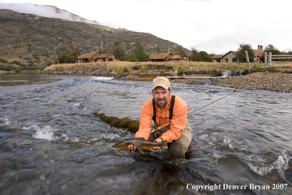 Flyfisherman holding brown trout.