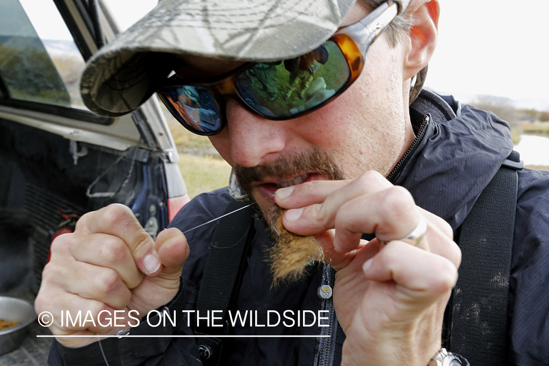 Flyfisherman tying fly.