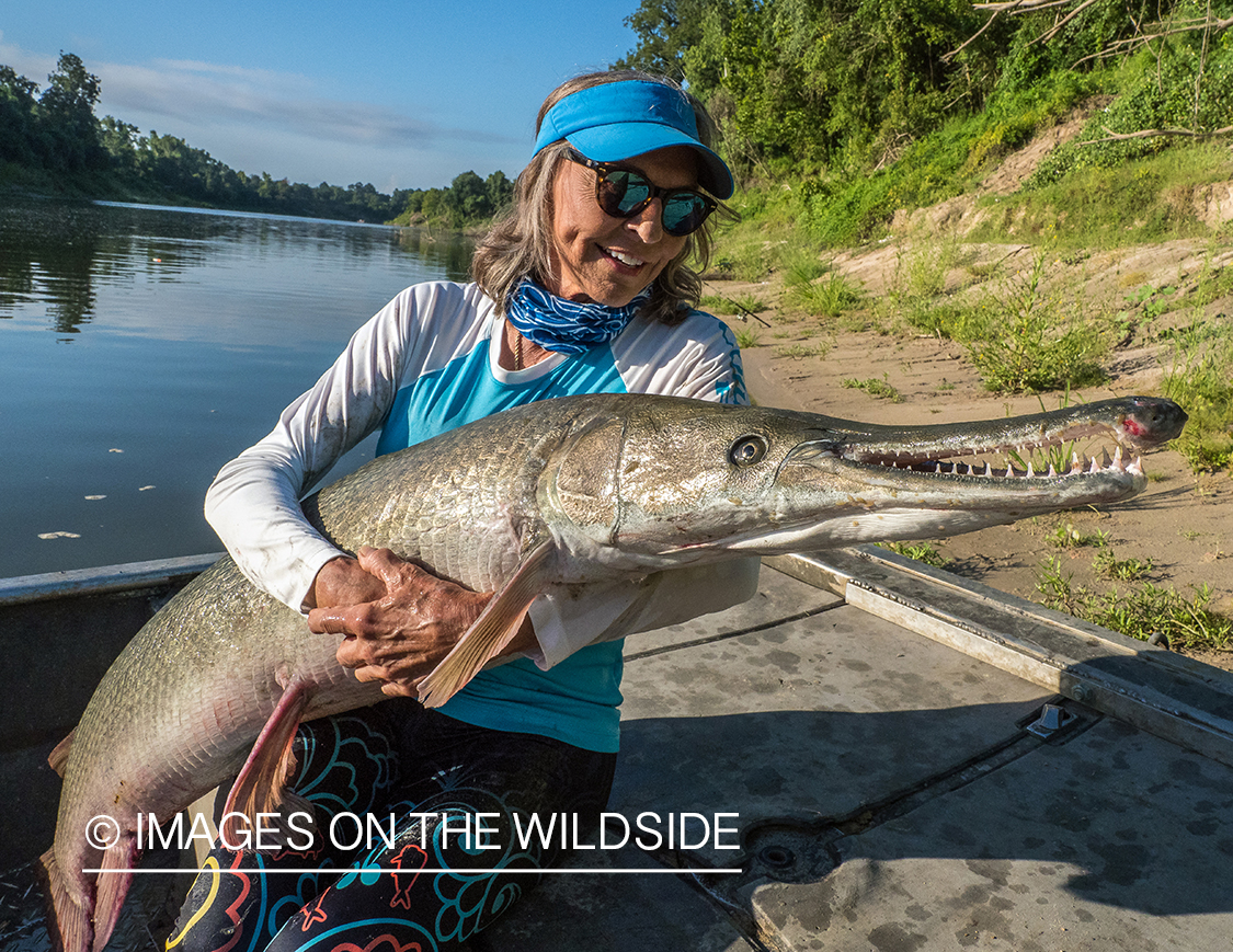 Female flyfisherman with Alligator gar.