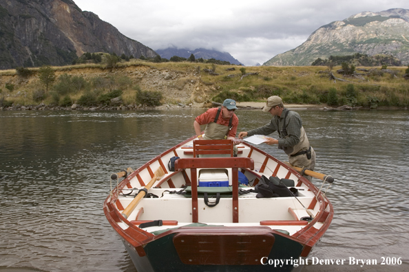 Flyfishermen choosing flies at driftboat.