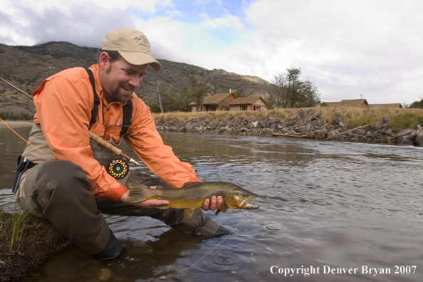 Flyfisherman holding brown trout.