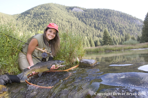 Woman flyfisher with large brown trout.