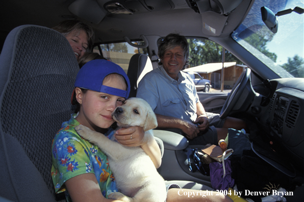 Family with yellow Labrador Retriever puppy