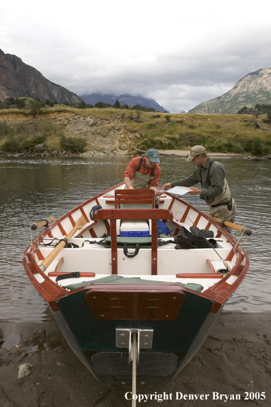 Flyfishermen choosing flies at driftboat.