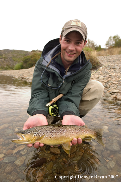 Flyfisherman holding brown trout.