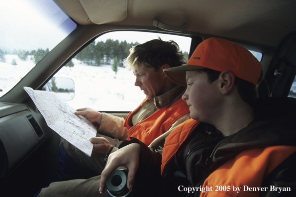 Father and son hunters planning big game hunting strategy.