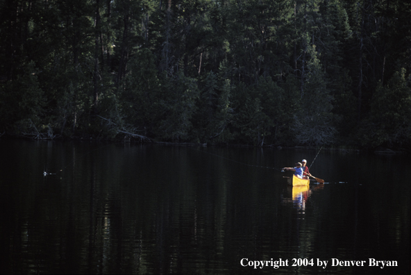 Father and son fishing from cedar canoe.