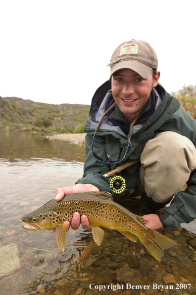 Flyfisherman holding brown trout.