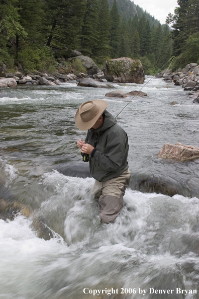 Flyfisherman fishing water pocket in river.