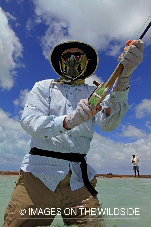 Saltwater flyfisher fighting fish on line, Christmas Island.