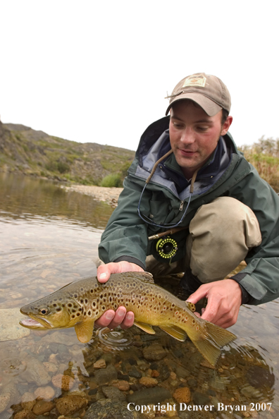 Flyfisherman holding brown trout.