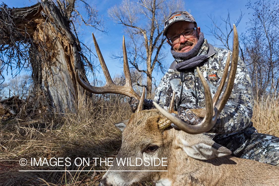 Bowhunter with bagged white-tailed buck. 