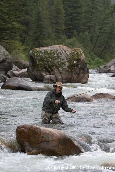 Flyfisherman fishing water pocket in river.