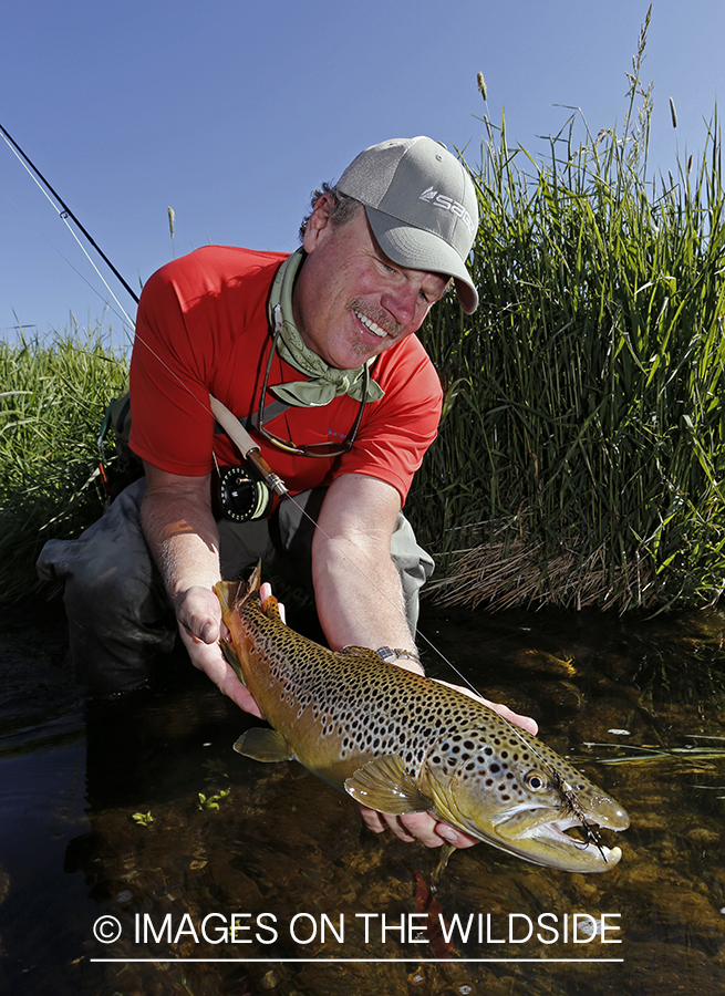 Flyfisherman with brown trout. 