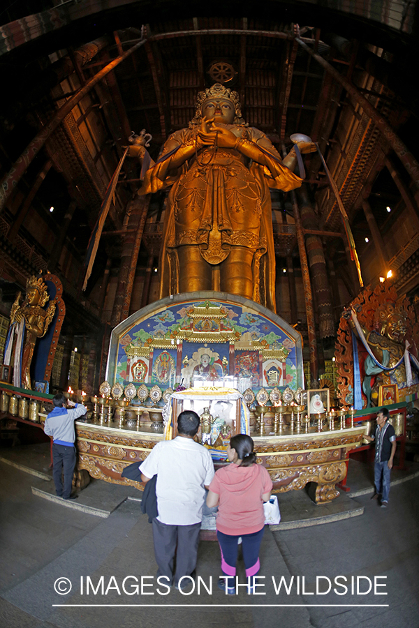 People in monastery at Buddhist statue, Ulaanbaatar, Mongolia. (97' tall)