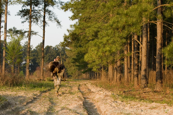 Turkey hunter in field with bagged bird