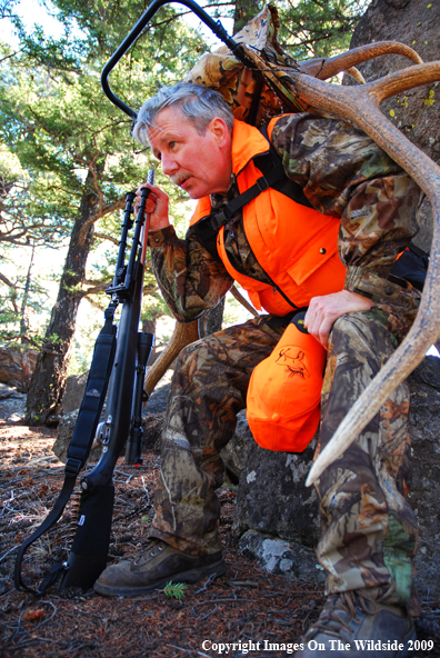 Hunter in field with elk rack.