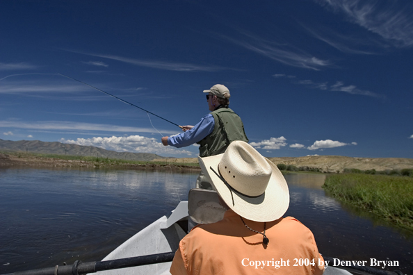 Flyfishermen fishing river from drift boat.  Summer.