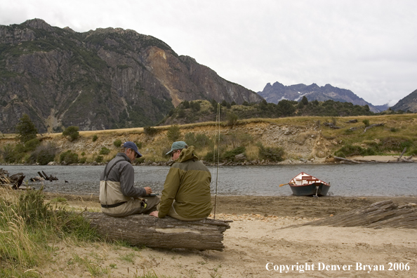 Flyfishermen choosing flies.  Driftboat in background.