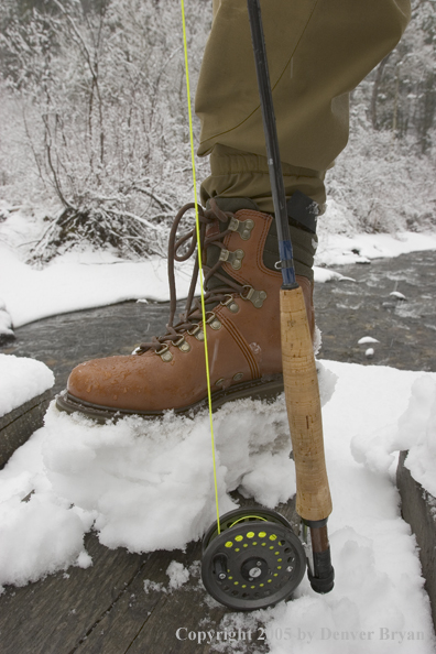 Fisherman's boot and rod/reel in snow.