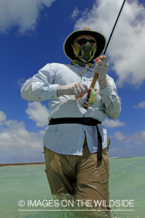 Saltwater flyfisher fighting fish on line, Christmas Island.