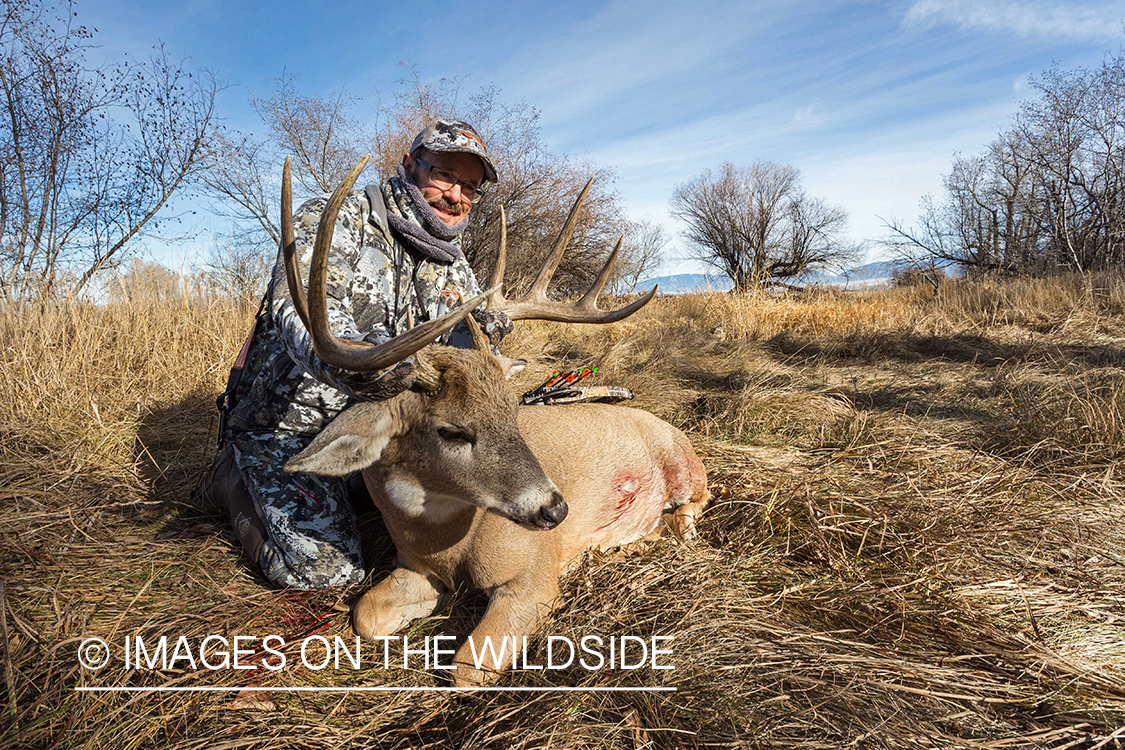 Bowhunter with bagged white-tailed buck. 