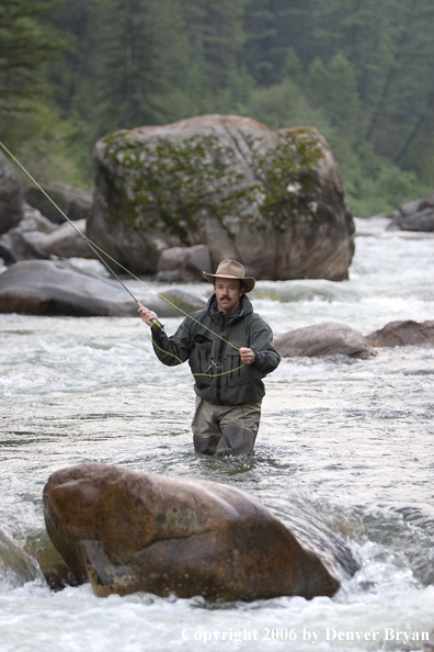 Flyfisherman fishing water pocket in river.