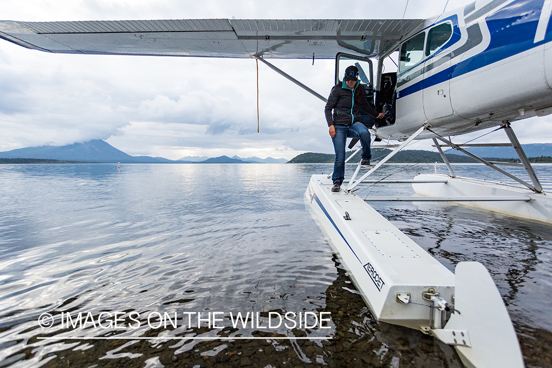 Flyfisher Camille Egdorf stepping out of float plane. 