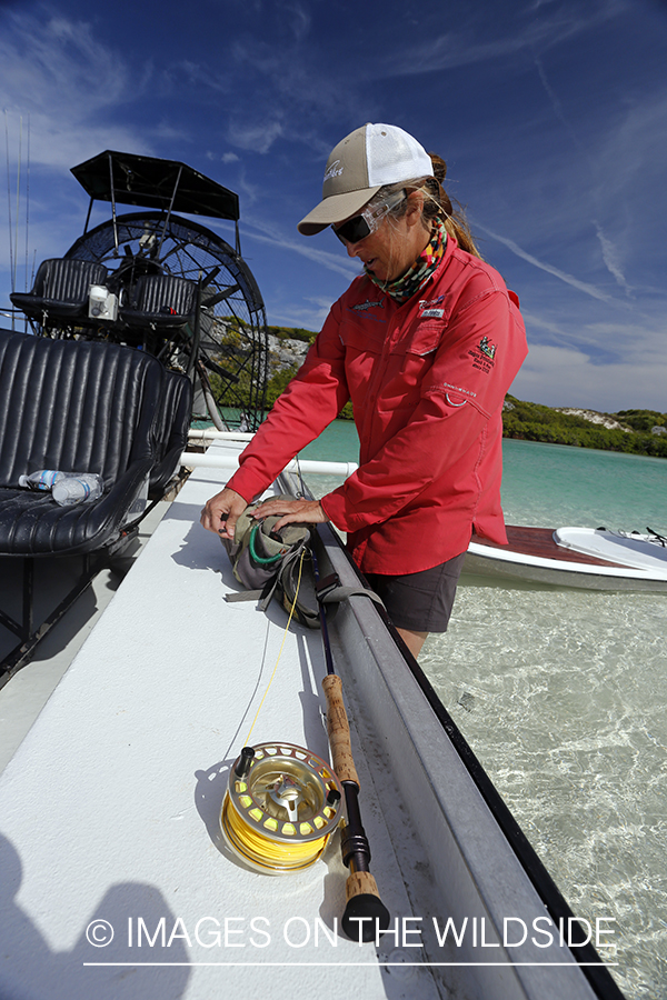 Saltwater flyfishing woman by airboat getting ready to fish.