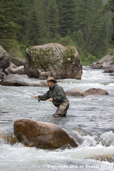 Flyfisherman fishing water pocket in river.