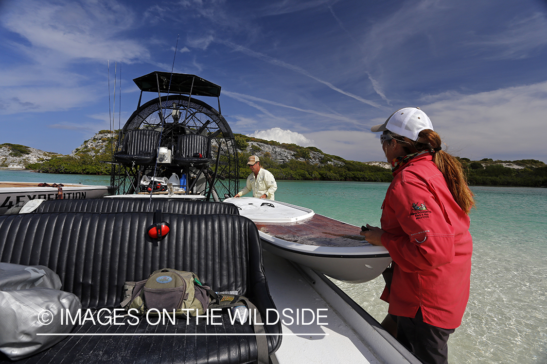 Saltwater flyfishermen unloading paddle board from airboat.