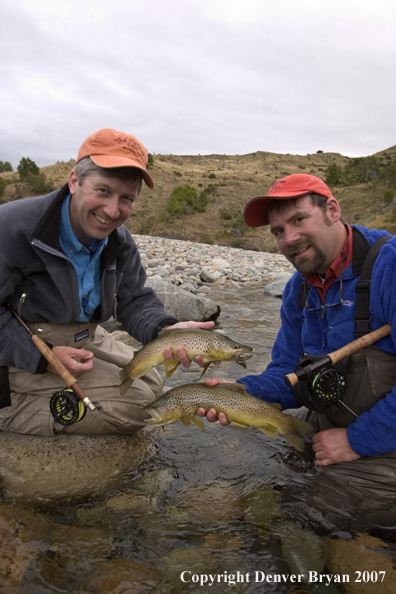 Flyfishermen holding brown trout.