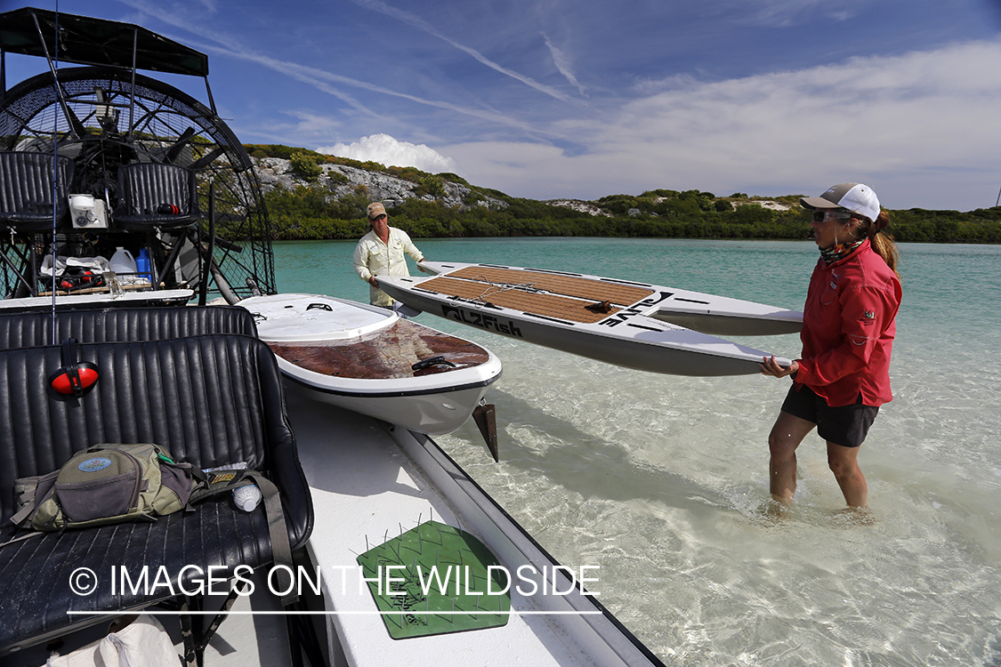 Saltwater flyfishermen unloading paddle board from airboat.