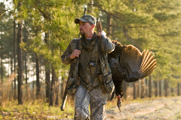 Turkey hunter in field with bagged bird