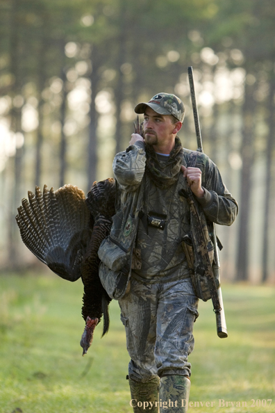 Turkey hunter in field with bagged bird